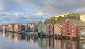 Colorful buildings along a river with reflections in the water.