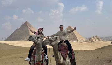 People riding camels near pyramids in Egypt.