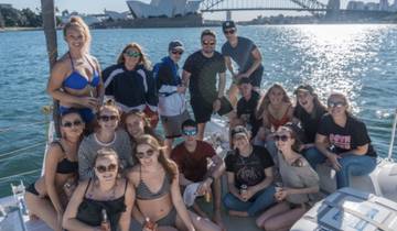 Group of friends posing on a boat with a cityscape in the background.