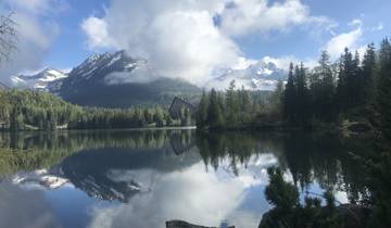 Reflective lake with snowy mountains in the background.