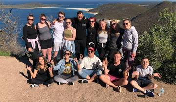 A group of people posing with a scenic ocean view in the background.
