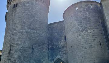 Historic stone building with a bright sun in the background.