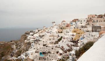Panoramic view of white buildings on a cliff overlooking the sea.