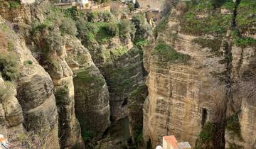 Scenic cliffside with a view of the valley and town.