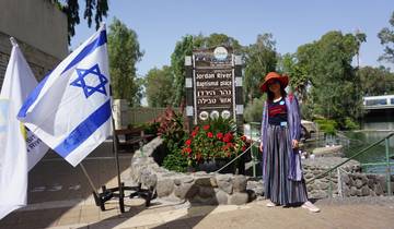 Individual standing near Jordan River Baptism place sign.