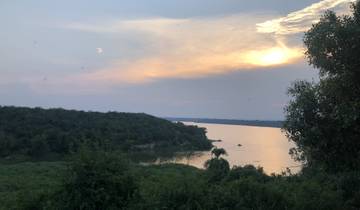 Sunset over a lake with trees in the foreground.