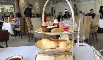 Afternoon tea setup with pastries and people in the background.