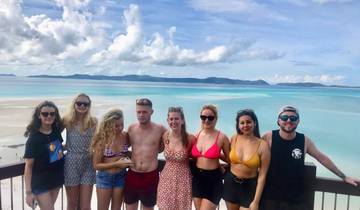 Group posing on a boardwalk overlooking a coastal scene.