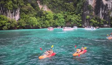 People kayaking with cliffs in the background.