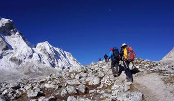 People trekking in a snowy mountainous landscape.