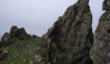 Sharp rocky cliff under a cloudy sky.