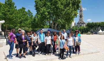 Group photo with a large sculpture in a park.