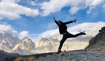 Person jumping joyfully with mountains in the background.