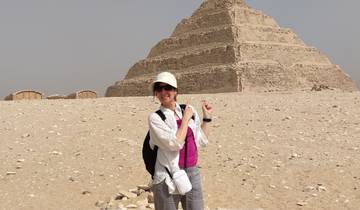 Person posing in front of a step pyramid.
