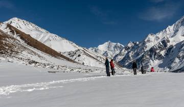 People hiking in a snowy mountain landscape.