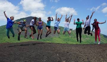 Group jumping with a mountain in the background.