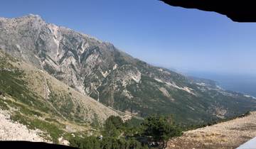 Panoramic view of a mountainous coastline under a clear sky.
