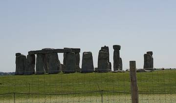 Stonehenge with a blue sky and a grassy foreground.
