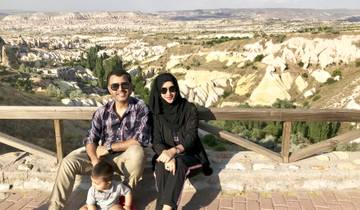 Family sitting and posing with rocky landscape behind.