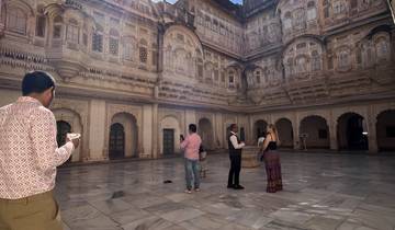A group of people standing in a historical courtyard with intricate architecture.