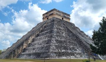 The pyramid of Chichen Itza under a blue sky.