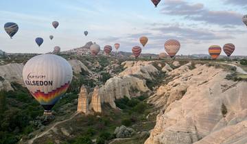 Hot air balloons floating over a rocky landscape.