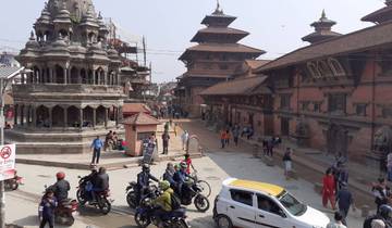 Traditional architecture with tourists and vehicles.