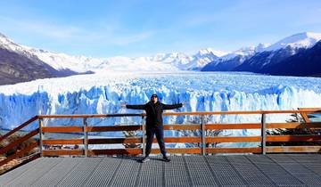 Person standing with arms wide open in front of Perito Moreno Glacier.