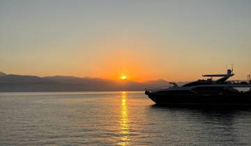 Luxurious yacht silhouetted against a sunset on the water.