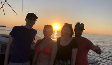 Group of four people on a boat during sunset.