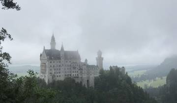 A castle in the mountains surrounded by mist.