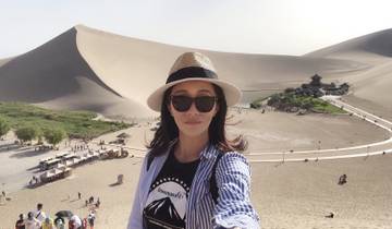 Person in front of sand dunes and a scenic area