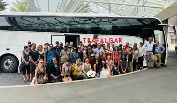 Group photo in front of a tour bus labeled 'Trafalgar'.