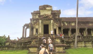 Tourists climbing steps towards an ancient temple.