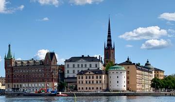 Riverfront with historic buildings and a spire.