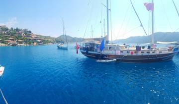 Sailboats anchored in a bright blue sea.