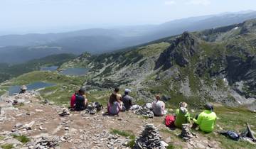 A group of hikers overlooking the stunning landscape of high mountains and lakes.