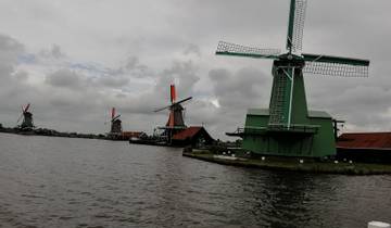 Scenic view of windmills by the water on a cloudy day.