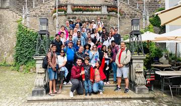 Large group photo on a set of stone steps with greenery.