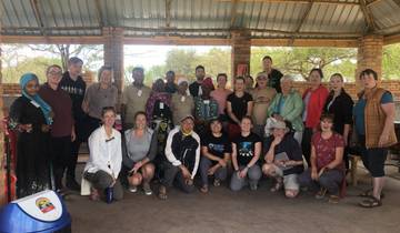 A large group posing inside a rustic building.