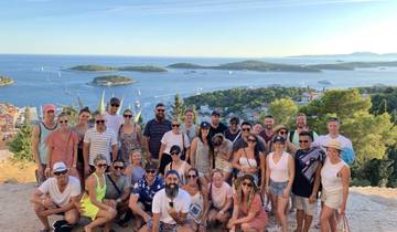 Large group of people posing with a scenic view of islands.