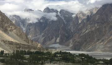 Dotted peaks of tall mountains emerging through clouds.