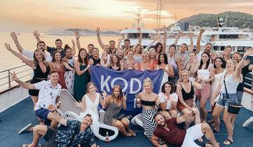 Large group celebrating on a boat during sunset.