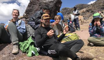 Group of hikers taking a break with snacks and drinks.