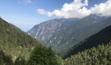 View of mountainous landscape with clouds touching the peaks.