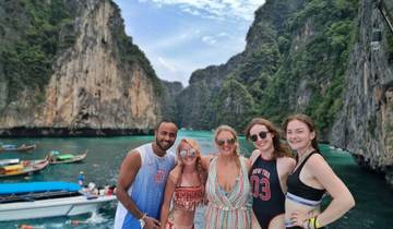 Group of people posing in front of stunning cliffs by the sea.