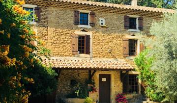 Stone house with flowers surrounding it.