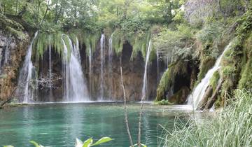 Beautiful waterfall with lush greenery and turquoise water.