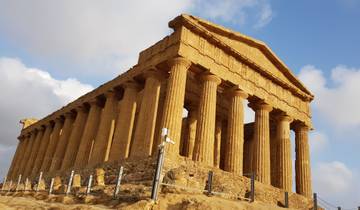 A well-preserved ancient temple with tall columns under a clear sky.