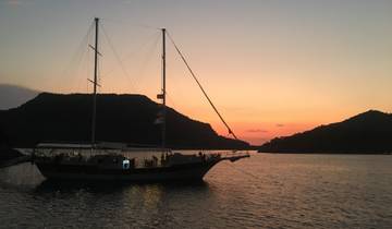 Sailboat anchored in a bay at sunset.